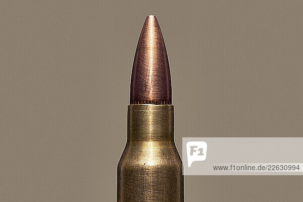Close up of .223 Remington bullet cartridge tip on brown background
