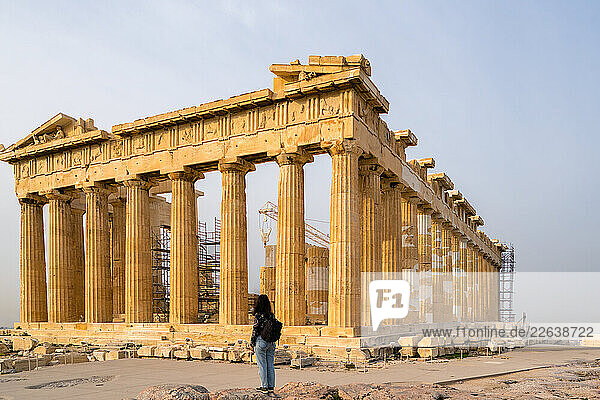 Woman looking at ancient temple dedicated to goddess Athena  Parthenon  UNESCO  Athens  Greece