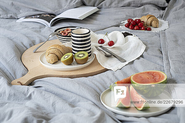 Frühstück im Bett mit Früchten und Croissants