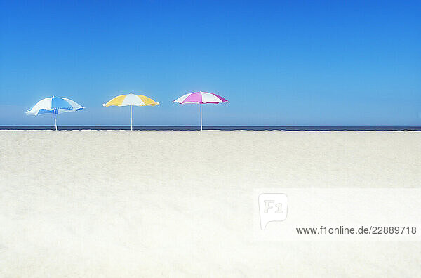 Colorful beach umbrellas on empty beach