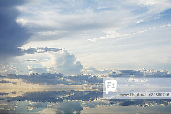 Sunset clouds reflected in calm water surface