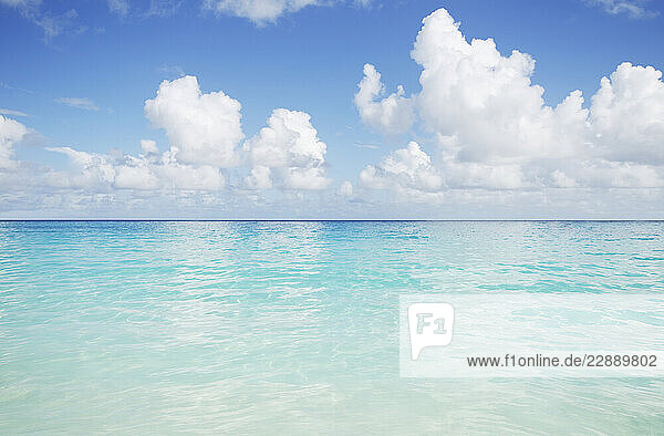Puffy clouds over calm Caribbean sea surface