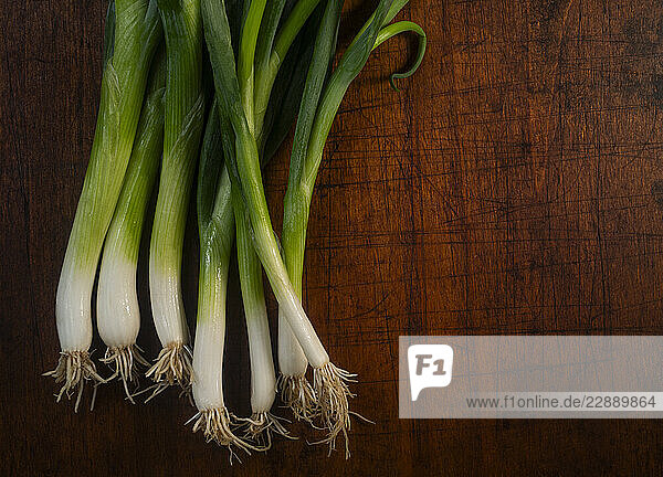 Bunch of scallions against rough cutting board