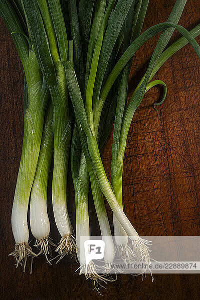 Bunch of scallions against rough cutting board