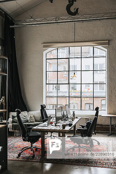 Modern office interior with computers and laptops on table