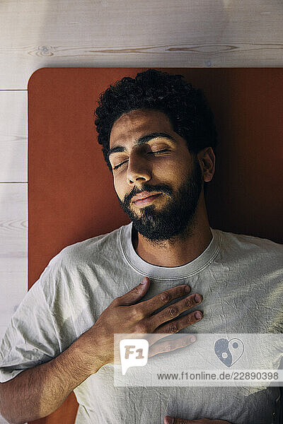 Directly above shot of man sleeping on exercise mat at home
