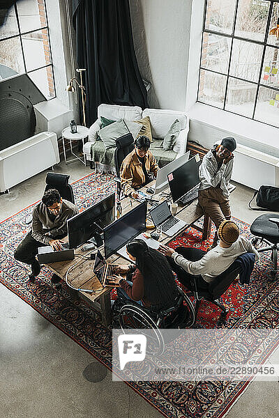 High angle view of entrepreneurs working at tech start up office