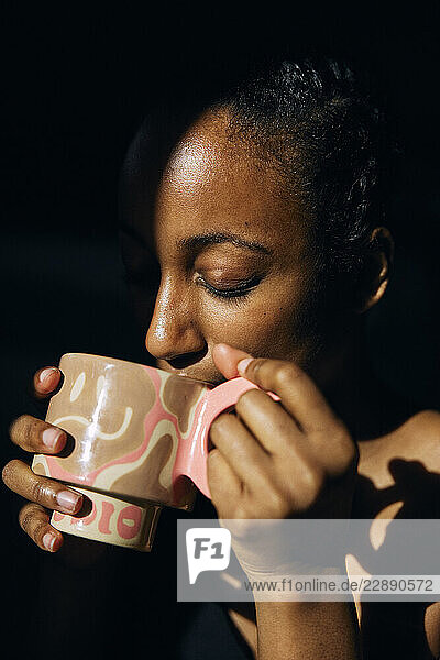 Woman drinking coffee from mug at home