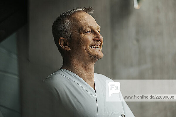 Smiling mature male physician looking away