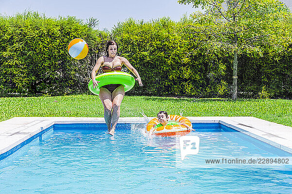 Mother and son playing in a pool on a sunny day in Argentina