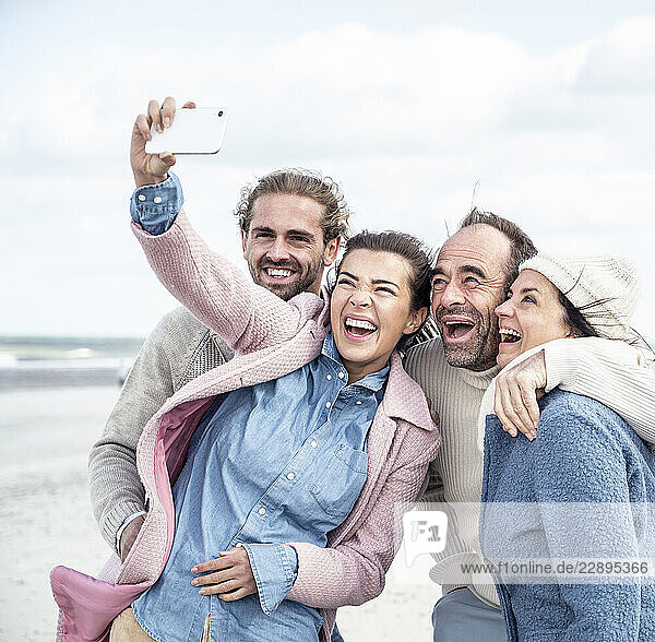 Group of friends taking selfie at beach