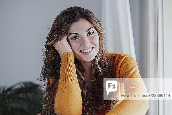Woman with wavy brown hair at home
