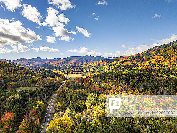 Aerial view of the Adirondack Mountain Range in Keene  New York  showcasing a scenic drive through vibrant autumn foliage.