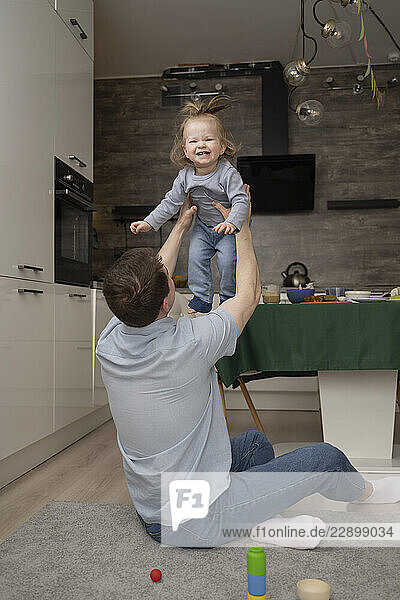 Father playing with his daughter at home in the living room