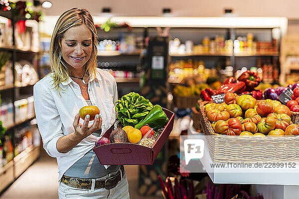 Woman examining fresh vegetable at organic store