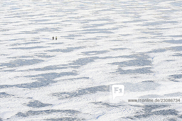 Two snowkiters survey the frozen Missouri River during the 2XtM expedition.