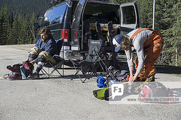 Backcountry snowboarders gearing up on the side of the road