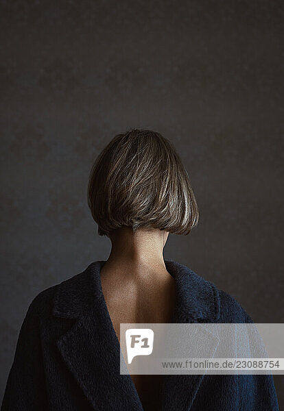 Back view on a blond woman wearing coat vice versa