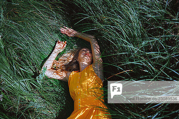 Carefree and serene blond woman relaxing in a grass