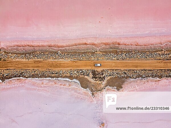 Drone view of camper van driving on a road in the pink Tuz salt lake in Turkey